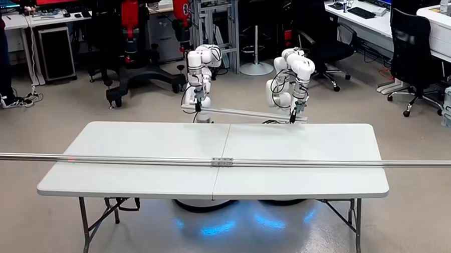 The evaluation rig, two robot arms at a shared table